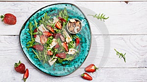 Salad with arugula, strawberries and cheese brie, camembert. Healthy food diet food concept. recipe background