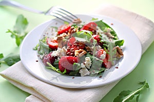 Salad with arugula, strawberries, goat cheese and walnuts