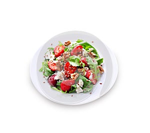 Salad with arugula, strawberries, goat cheese and walnuts isolated