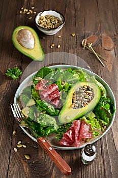 Salad with avocado, salami, pine nuts, pumpkin seeds and sunflower seeds
