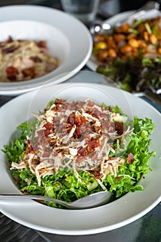 Salad with bacon and chicken, cesar salad background. lettuce salad close-up on a plate on a table