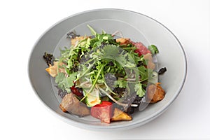 Salad with baked eggplant. Baked eggplant with arugula and tomatoes and cucumbers. Plate on a white background. Photos