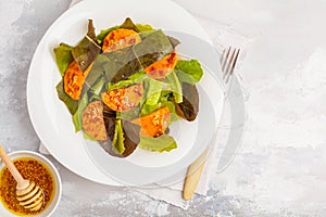 Salad with baked pumpkin with mustard-honey dressing in a white