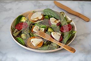 Salad on bamboo plate on marble table