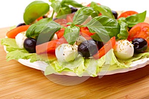 Salad with basil, mozzarella, olives and tomato