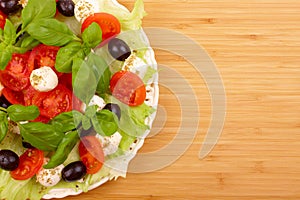 Salad with basil, mozzarella, olives and tomato