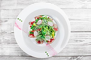 Salad with beef steak, baby spinach, lettuce, sweet pepper and grains of pomegranate on wooden background close up