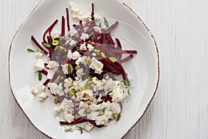 Salad with beetroot and feta cheese on the white plate