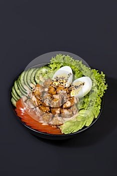 Salad bowl with chicken breast, rice, tomatoes, cucumbers and avocado Boiled egg