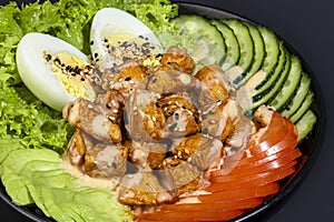 Salad bowl with chicken breast, rice, tomatoes, cucumbers and avocado Boiled egg