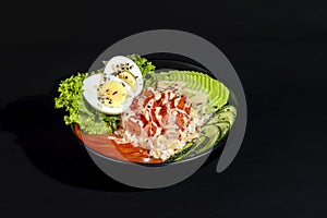 Salad bowl with salmon rice, tomatoes, cucumbers and avocado. Boiled egg.