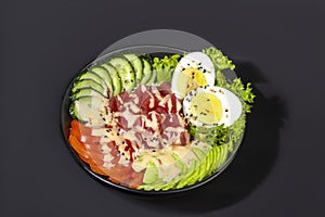 Salad bowl with tuna rice, tomatoes, cucumbers and avocado. Boiled egg.