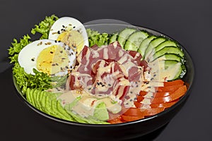 Salad bowl with tuna rice, tomatoes, cucumbers and avocado. Boiled egg.