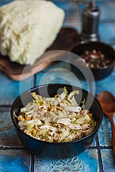 Salad with cabbage, eggs, corns and meat on the plate on rustic tiled table