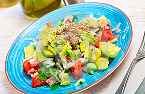 Salad with canned tuna on blue plate