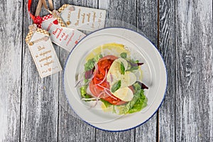 Salad with cheese and tomatoes on wooden background. The view from the top