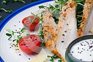 Salad with chicken Caesar salad with micro-greens, cherry tomatoes and parmesan on a blue ornament background