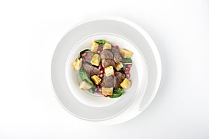 Salad with chicken liver and spinach in the white plate top view