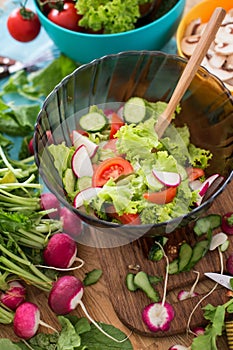 Salad from chopped spring vegetables in the glass bowl