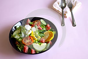 Vegetable salad on a black plate Weight loss concept Healthy food photo