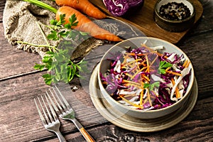 Salad Cole Slaw. Autumn Cabbage salad in a bowl on a rustic wooden table.