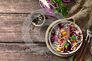 Salad Cole Slaw. Autumn Cabbage salad in a bowl on a rustic wooden table. Flat lay top view.