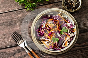 Salad Cole Slaw. Autumn Cabbage salad in a bowl on a rustic wooden table. Flat lay top view.