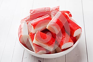 Salad crab sticks in a plate on a white table