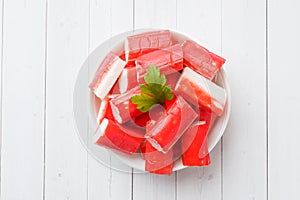 Salad crab sticks in a plate on a white table