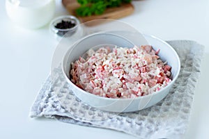 Salad with crab sticks and tomatoes in a white bowl on a white napkin