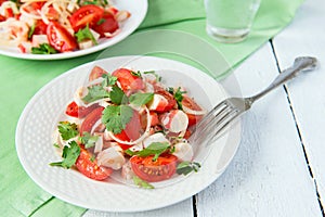 Salad from crabmeat sticks, tomatoes and parsley