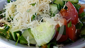 Salad cucumber tomatoes cheese slow-motion shot, watered with oil