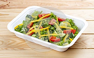 Salad with cucumber, tomatoes and sweet pepper. Healthly food. Takeaway food. On a wooden background