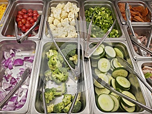 Salad and food bar with stainless steel pans and tongs
