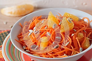 Salad of fresh carrots with sunflower seeds and orange