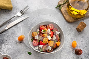 Salad with fresh colorful cherry tomatoes, basil and olive oil