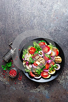 Salad with fresh and grilled vegetables and mushrooms. Vegetable salad with grilled champignons. Vegetable salad on plate