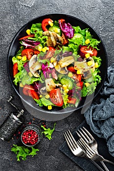 Salad with fresh and grilled vegetables and mushrooms. Vegetable salad with grilled champignons. Vegetable salad on plate