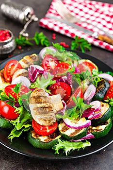 Salad with fresh and grilled vegetables and mushrooms. Vegetable salad with grilled champignons. Vegetable salad on plate