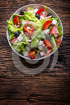 Salad. Fresh summer lettuce salad.Healthy mediterranean salad olives tomatoes parmesan cheese and prosciutto