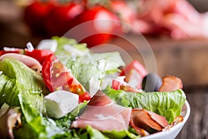 Salad. Fresh summer lettuce salad.Healthy mediterranean salad olives tomatoes parmesan cheese and prosciutto