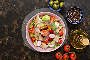 Salad of fresh vegetables with bread fattoush closeup. Arabic dish fattoush on a dark background, top view.