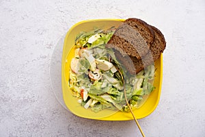 Salad of fresh vegetables and crab sticks in a plastic container. The concept of healthy eating