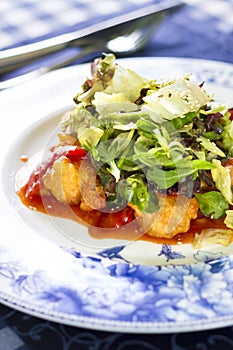 Salad with fried fish fillet, red pepper and salad mix