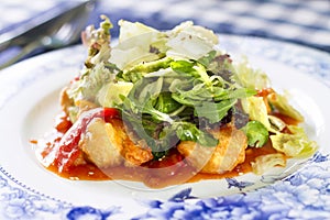 Salad with fried fish fillet, red pepper and salad mix