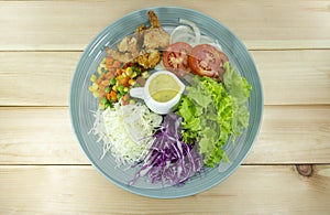 Salad fried shrimp fresh vegetables in a blue plate