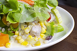 Salad with fruit and fresh vegetable topped with salad dressing