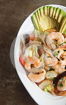 salad with garlic, avocado and prawns on a table