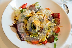 Salad with goat cheese, cherry tomatoes, arugula, nuts and raisins