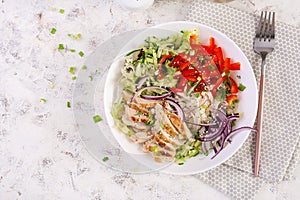 Salad with grilled chicken breast, fillet and lettuce, daikon, red onions, cucumber and sesame. Healthy lunch menu. Diet